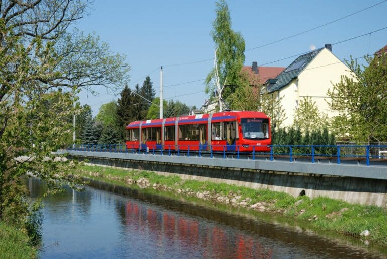 Eine Variobahn der Linie C11 fährt entlang des Flusses Würschnitz