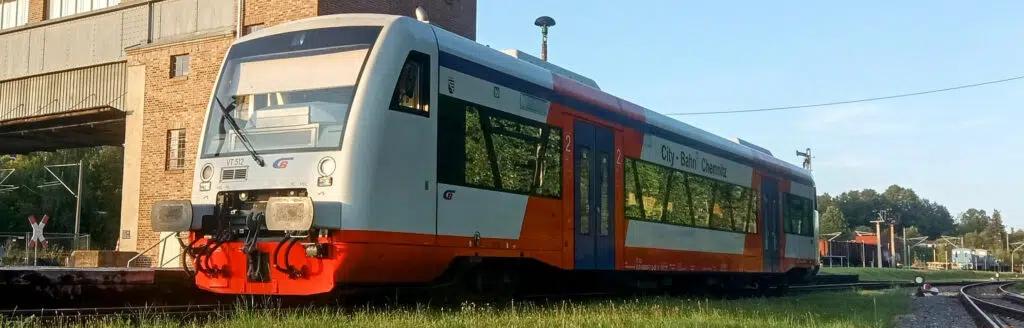 Ein City-Bahn RegioShuttle Typ RS1 steht vor einer Industrieanlage